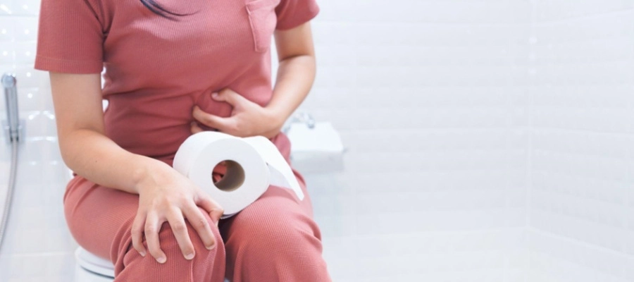 uma mulher sentada no banheiro com um rolo de papel higiênico no colo