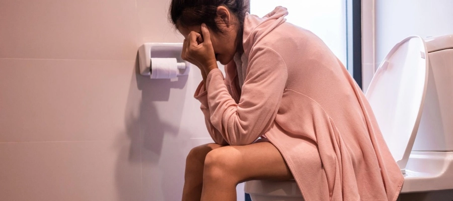 mulher no vaso sanitário com constipação
