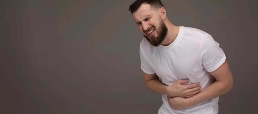 homem com barba e camisa branca com a mão na barriga