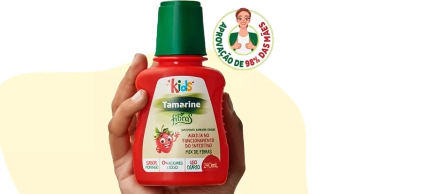 uma mão segurando uma garrafa de tamarine fibras kids