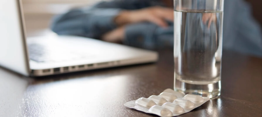 Mulher sentada na mesa pesquisando no computador se laxante vicia o intestino.