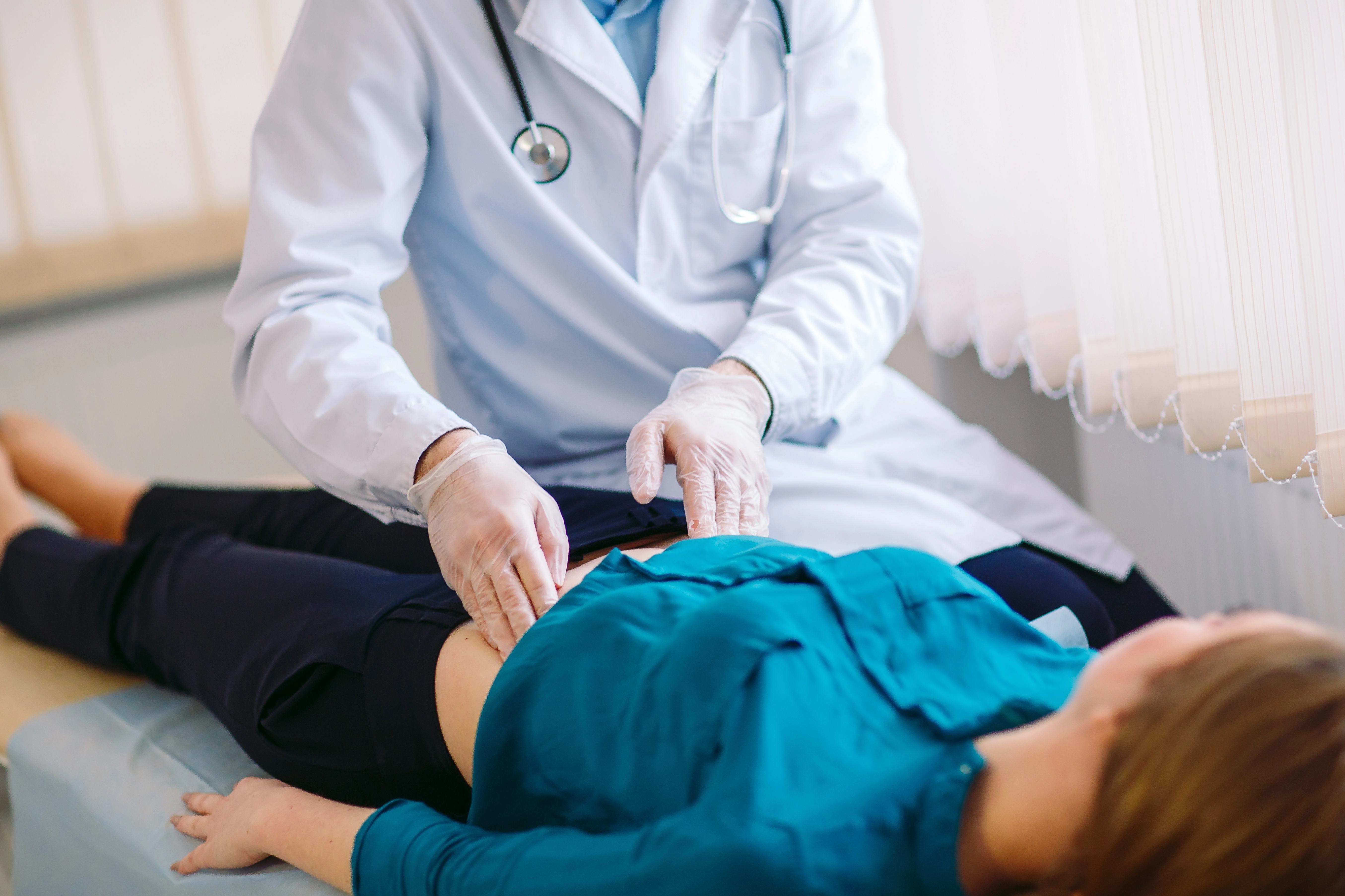 médico apalpa o ventre de paciente