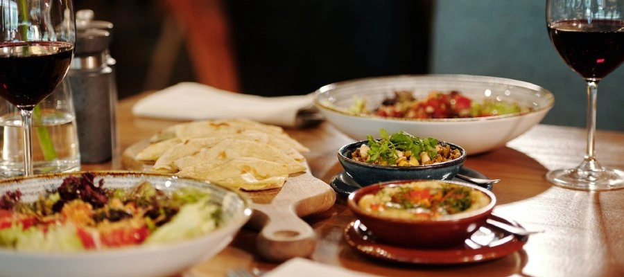 uma mesa com tigelas de comida e vinho