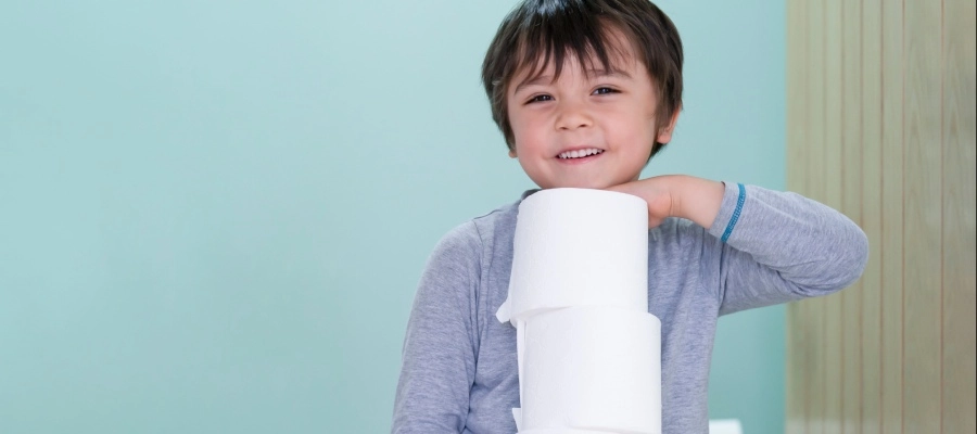 um menino segurando um rolo de papel higiênico