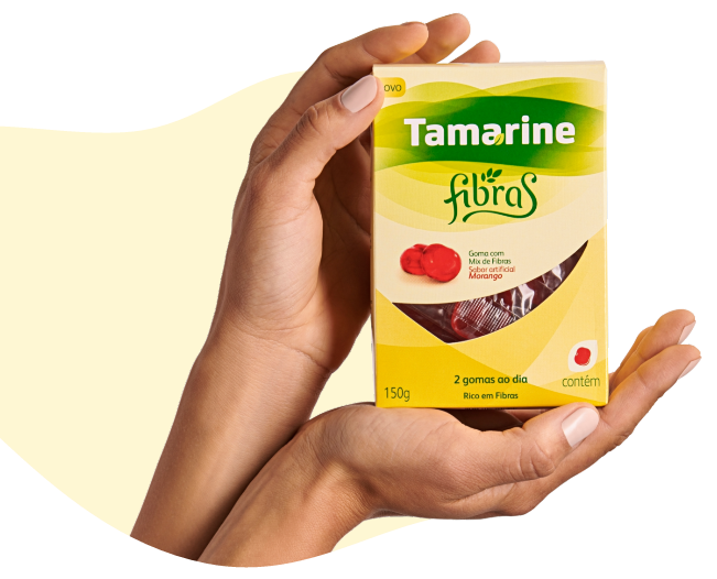 Imagem de uma mão segurando a embalagem do Tamarine Fibras em Gomas