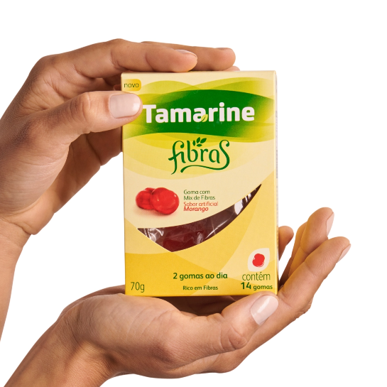 Imagem de uma mão segurando a embalagem do produto Tamarine Fibras em Gomas