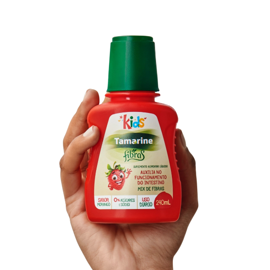 Imagem de uma mão segurando a embalagem do produto Tamarine Fibras Kids
